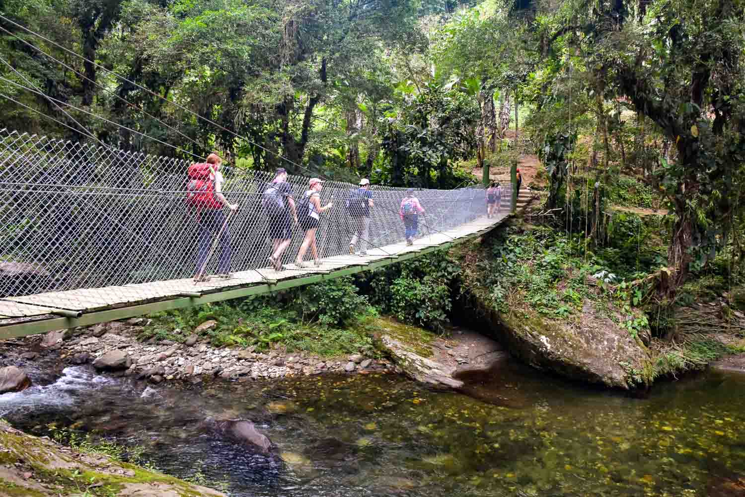 Les randonneurs traversent un pont au-dessus du Rio Buritaca vers la Ciudad Perdida